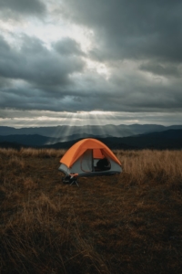 tent camping with sun rays through clouds
